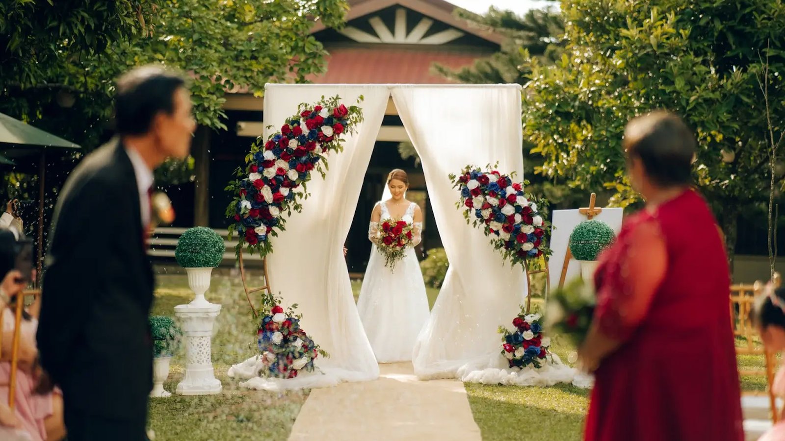 Bride enters a white-draped garden aisle in Savanna FarmTagaytay as guests watch, floral arches framing the ceremony path